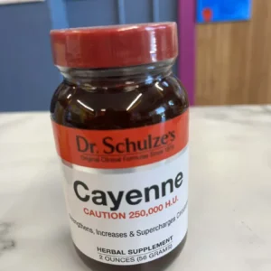 A 2 oz jar of Dr. Schulze’s Cayenne 250,000 H.U. organic herbal supplement sits on marble, labeled with a caution for its high heat level (250,000 heat units / 56 g).